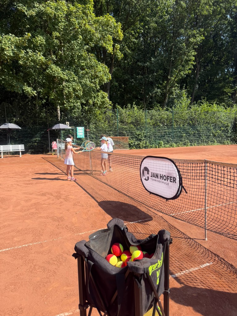 Kind vor dem JHT-Banner mit Ballkorb im Camp