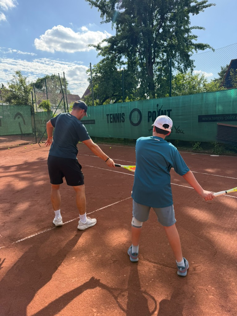 Trainer führt Kind beim Vorhandschwung im Einzelcoaching