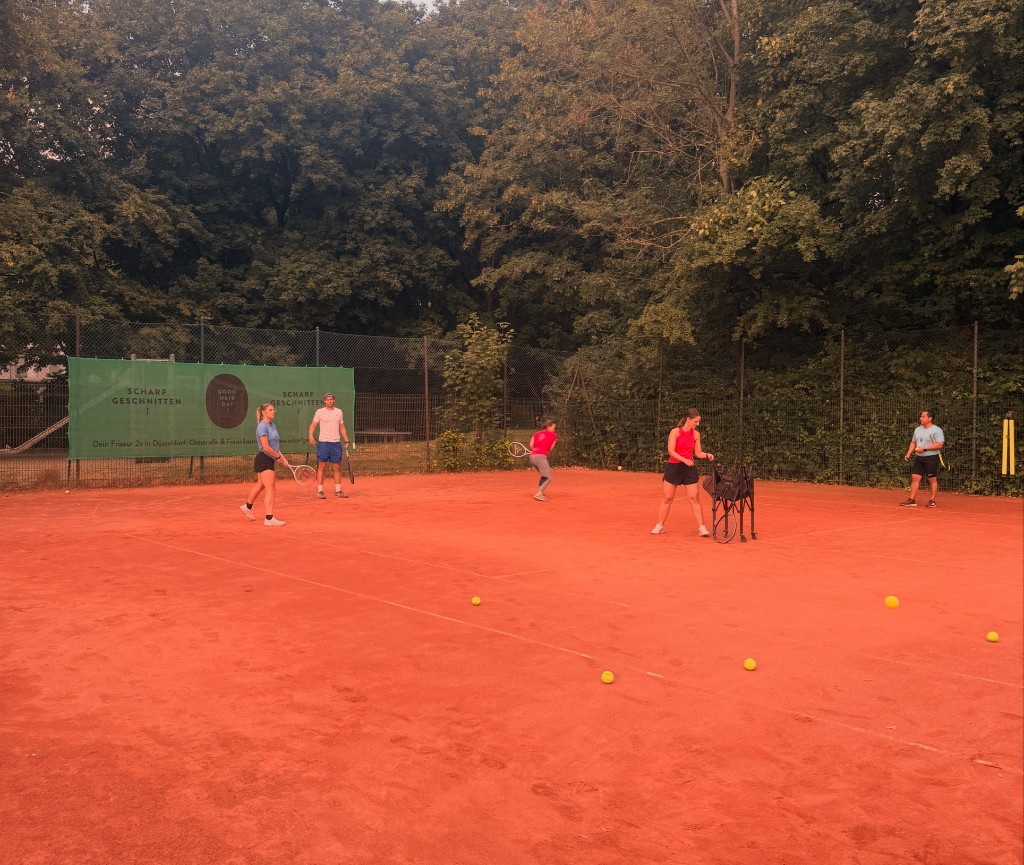 Erwachsene beim aktiven Tennistraining auf dem Sandplatz