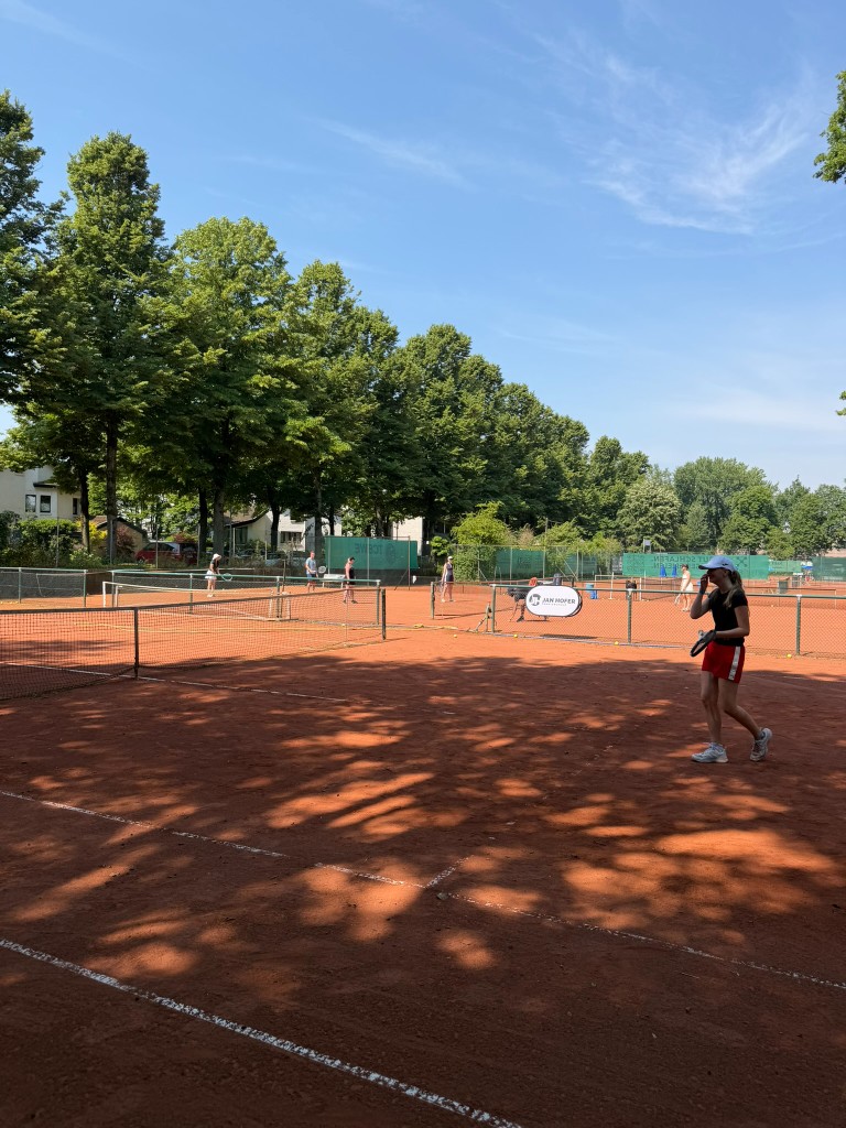 Spielerin auf der Tennisanlage mit mehreren Plätzen