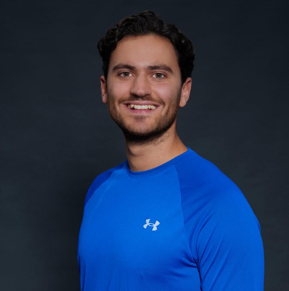 Leon, Tennistrainer, Portrait vor neutralem grauem Hintergrund – Jan Hofer Tennisschule